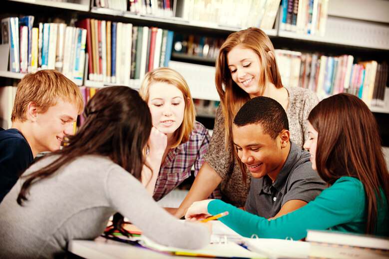 Schüler aus verschiedenen Ländern lernen gemeinsam in einer Bibliothek.